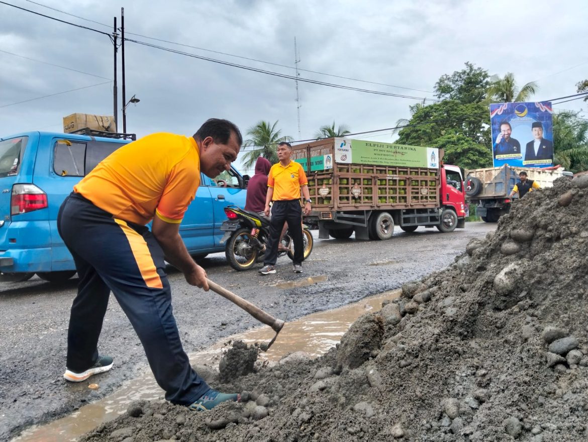 Bersama Warga, Personil Polsek Tanjung Pura Timbun Jalan Berlubang Demi Cegah Laka Lantas.