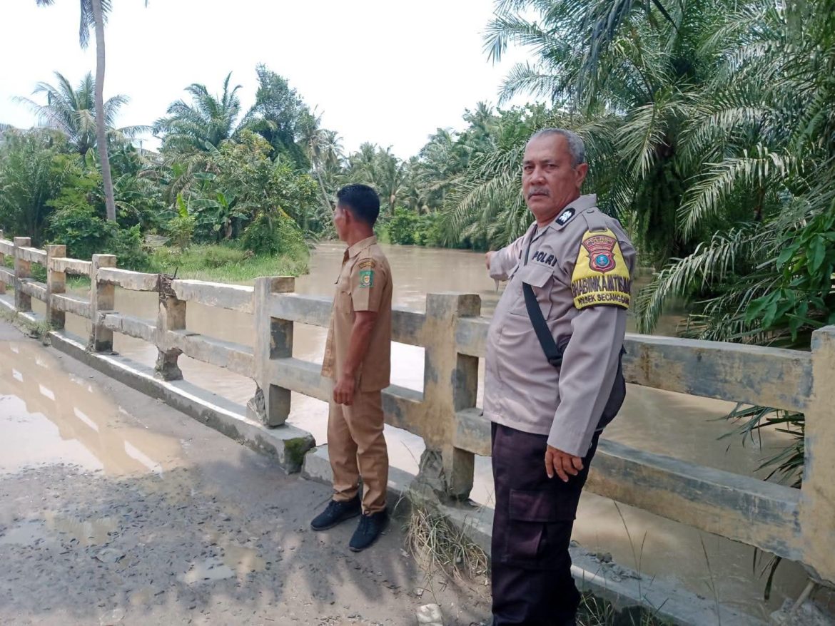 Bhabinkamtibmas Polsek Secanggang Pantau Ketinggian Air Sungai Perkotaan Pascahujan Deras.