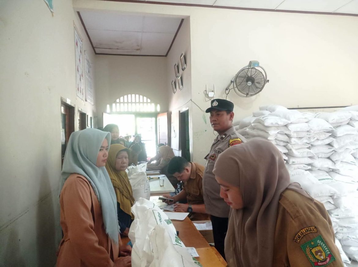 Bhabinkamtibmas Polsek Secanggang Monitoring Pembagian Beras Bulog di Desa Secanggang.