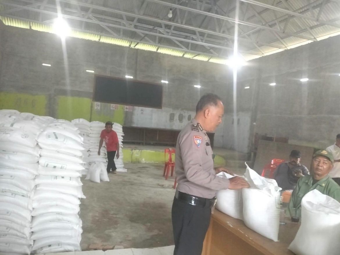 Bhabinkamtibmas Desa Telaga Jernih Monitor Pembagian Beras Bulog kepada Warga.